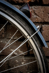 Bicycle wheel on a brick wall background - 402366071