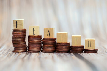 Word HEALTH on step stacked coins as graph up with white,gray background. Money savings or investment planning for life insurance and healthcare concept. business and financial concept