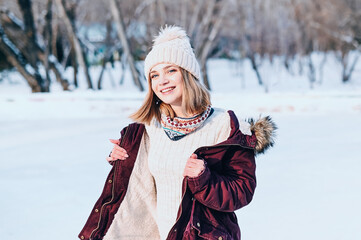 Fototapeta na wymiar Close-up portrait of happy girl enjoys falling snow