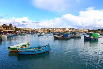 Fototapeta na wymiar Marsaxlokk, un village charmant maltais avec des bateaux colorés
