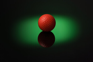 Golf ball over green circle of light.