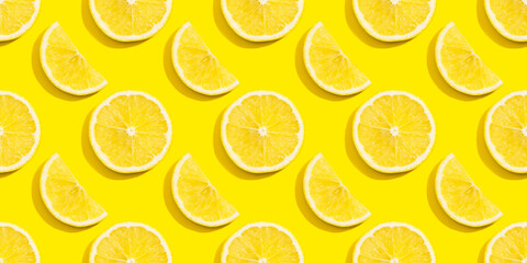Seamless pattern of lemon slices on a yellow background.