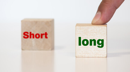 Hand turns a dice and changes the expression SHORT to LONG