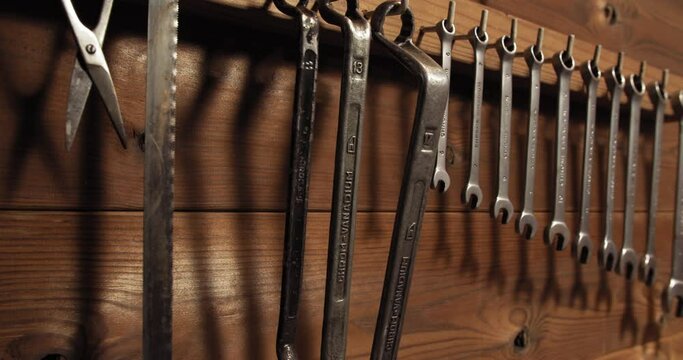 Old wrench set hanging on wooden wall in professional workshop garage
