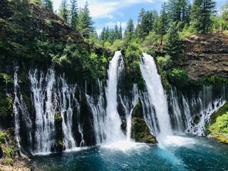 Fototapeta premium Multiple waterfalls coming out of forest mountain