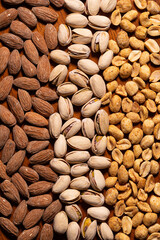 Pattern of pistachios, almonds, peanuts on wood table