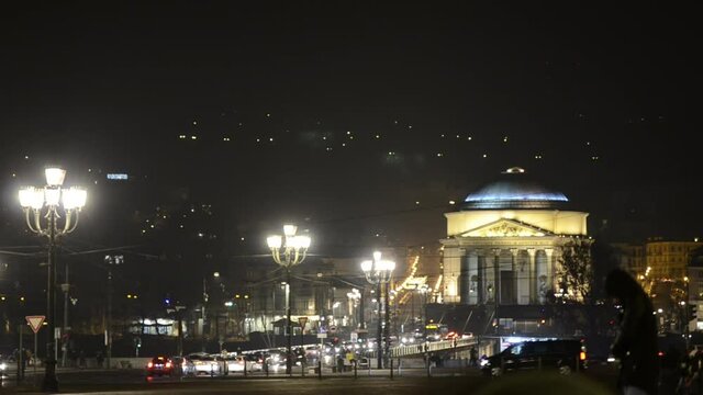 Turin, Piedmont, Italy. December 2018. Night footage of the Church of the Gran Madre di Dio from the bank of the river Po next to Piazza Vittorio. Characteristic street lamps, traffic and people.
