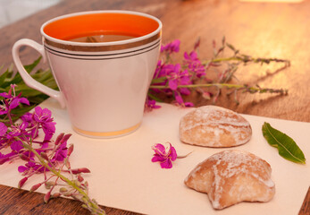 Still life photo with herbal tea from fireweed leaves and gingerbread on a wooden background