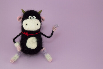 knitted black bull on purple background. 2021 symbol