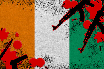 Ivory Coast flag and guns in red blood. Concept for terror attack and military operations