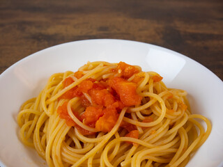 plate of spaghetti pasta with tomato sauce viewed from above on dark wooden table background, Italian recipe