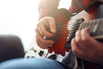 Stylish guy learning to play the guitar at home. Video communication training. Distance learning....