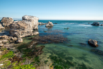 Fototapeta premium Sea kayaking overlooking Pacific ocean, rocky cliffs and caves, California coastline