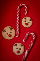 Postcard New Year's decor, gingerbread cookies, New Year's deer, candy in the form of heart on red background