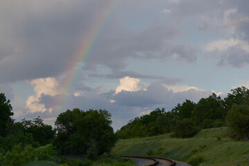 Fototapeta na wymiar Rainbow in the rain on the railway
