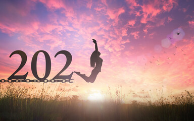 Success new year 2021 concept: Silhouette of a woman jumping and broken chains with text for 2021...
