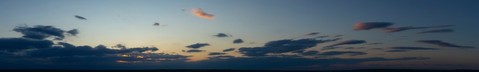 Fototapeta na wymiar The evening sunset. Panorama. Purple clouds. Tragic gloomy sky.