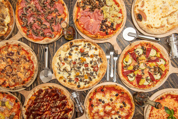 Fototapeta na wymiar overhead shot of pizzas on dark wooden table