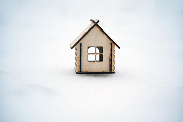 Obraz na płótnie Canvas Close up of small wooden house on snow in wintertime. Concept of purchasing new apartment.