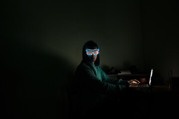 A man at a computer in the dark.