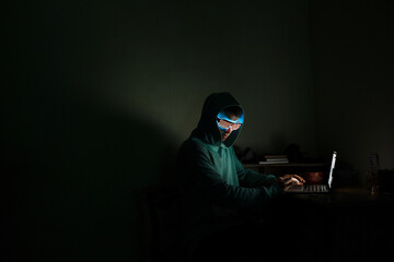 A man at a computer in the dark.