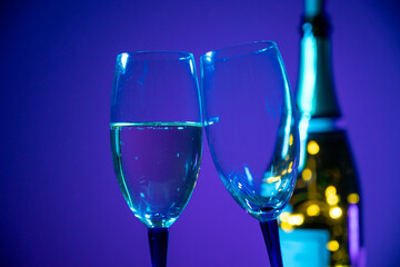 Sektgläser auf blauem Hintergrund. Champagnerflasche im Hintergrund