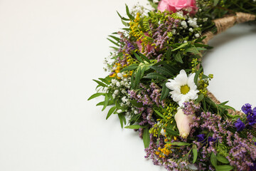 Wreath made of beautiful flowers on white background, closeup. Space for text
