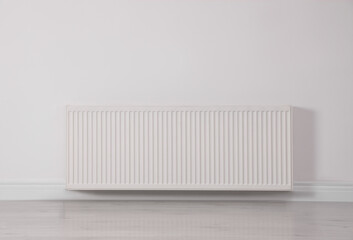 Modern radiator on white wall. Central heating system