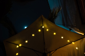 Sun umbrella at night with warm lights