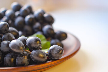 Blue grapes on a clay plate