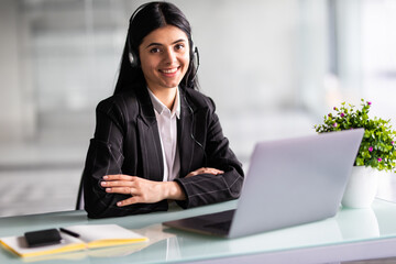 Young and confident customer support operator working in a call center in office