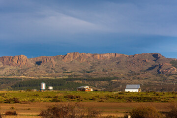 Fototapeta na wymiar Rural scene of barn and silo in the mountains during sunset in Trevelin, Patagoni, Argentina