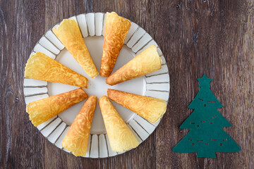 Norwegian Krumkake cookies on a distressed white platter on a rustic wood background
