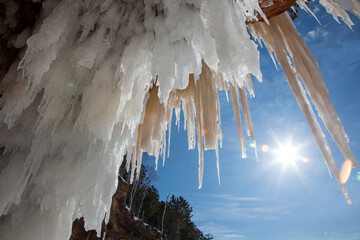 Gigantic icicles hanging off of rock formations and ice caves on a bitter cold day - obrazy, fototapety, plakaty