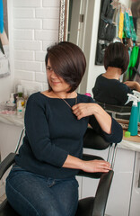 Brunette woman with short bob haircut in full face with reflection in the mirror