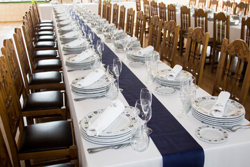 table with tablecloth and cutlery set up for the food of the guests