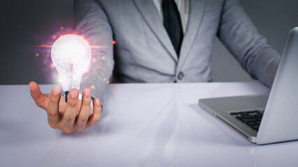 Hand of businessman holding light bulb, innovative technology. Mixed media, digital concepts.