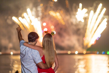Young couple enjoy firework during celebration festival on the beach.