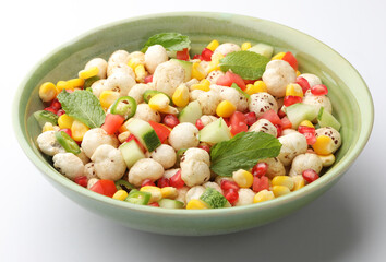 makhana salad or foxnuts salad with pommegranate, sweet corn, tomato, cucumber and chopped green chillies. Makhana is a healthy snack with high nutritional value mostly popular in North India
