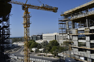 scaffolding in construction works. Tower crane in a new civil construction site Building in Oman. Oman city. Muscat, Oman
