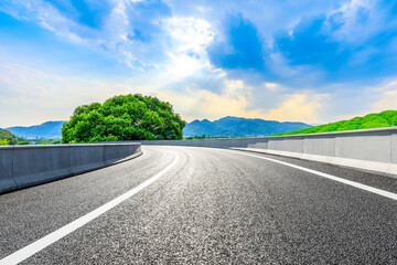 Asphalt road and mountain with tea plantation under blue sky.Road and mountain background.