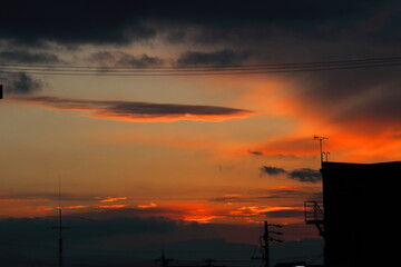 Fototapeta na wymiar 冬の夕暮れのオレンジ色に染まった空とシルエット