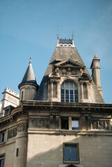 Fototapeta na wymiar Antique roof with turrets and an attic window on a house in the historic center of Paris.