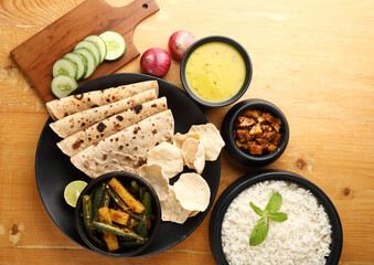 Bhindi masala or ladies finger fry curry ,yellow daal ,pickle,papad ,rice ,salad served with indian roti / chapati or Indian Flat bread ,north indian food