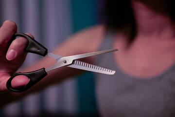 A woman holding scissors for cutting hair
