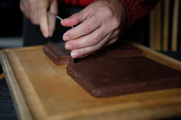hands of a person cutting Chocolate