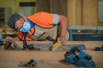 Front view photo of focused professional hardwood worker making slab coffee table use spirit level...