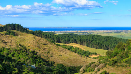 Fototapeta na wymiar Panoramic view from the Papamoa Hills in the Bay of Plenty, New Zealand, looking towards the ocean. The coastal suburb of Papamoa can be seen in the distance