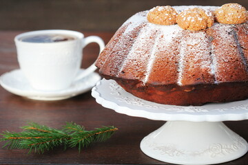 Chocolate bundt cake with icing sugar and coffee cup. Christmas background