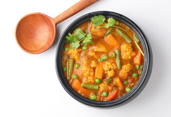 MIX VEGETABLE CURRY- indian recipe, mixed veg , Carrots, cauliflower, green peas and beans with traditional masala red hot and spicy served in a ceramic bowl